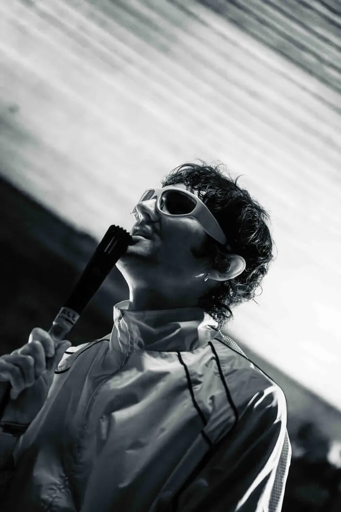 Black and white photo of a performer tilting their head back while singing into a handheld mic