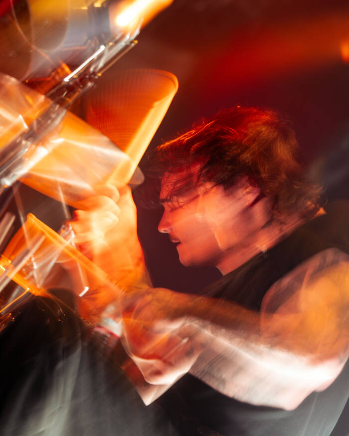 Long-exposure motion blur of a musician performing under warm orange stage light